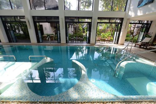 a swimming pool in a house with a large building at Rarin Jinda Wellness Spa Resort in Chiang Mai