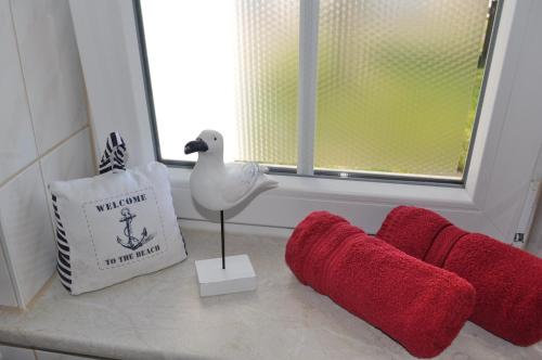 a room with a window with a swan statue and red objects at Pension Villa Frohsinn Sellin auf Rügen in Ostseebad Sellin