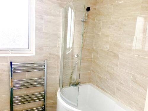 a bathroom with a shower and a bath tub at Studio Apartment, Private Bathroom and Parking in Ilford