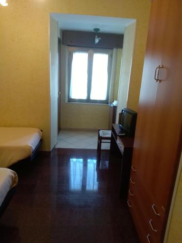 a hotel room with two beds and a television at Hotel Grazia Ristorante in LʼAquila