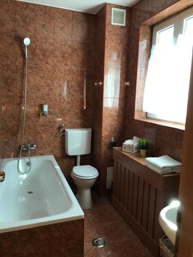 a bathroom with a tub and a toilet and a sink at Bucharest Downtown Inn in Bucharest