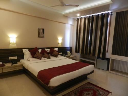 a bedroom with a large bed in a room at Hotel K Square in Kolhapur