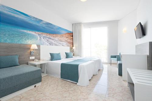 サン・アントニオ・ベイにあるazuLine Hoteles Mar Amantis & IIのベッド2台とソファが備わるホテルルームです。