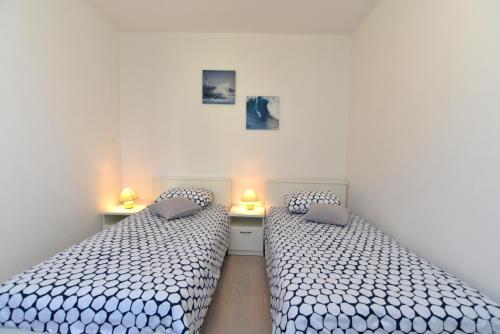two beds sitting next to each other in a bedroom at Apartments Petra 628 in Fažana