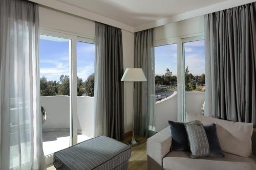 a living room with a couch and large windows at Blazer Suites Hotel in Athens