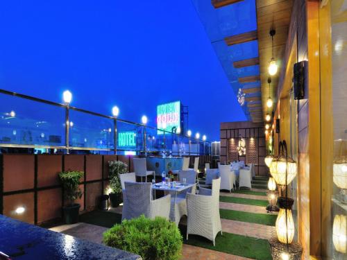 a restaurant with white tables and chairs at night at The Gold Regency - 02 Mins from New Delhi Railway Station in New Delhi