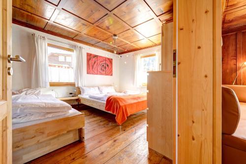 two beds in a room with wooden walls at Appartement Walserstuba by A-Appartments in Brand