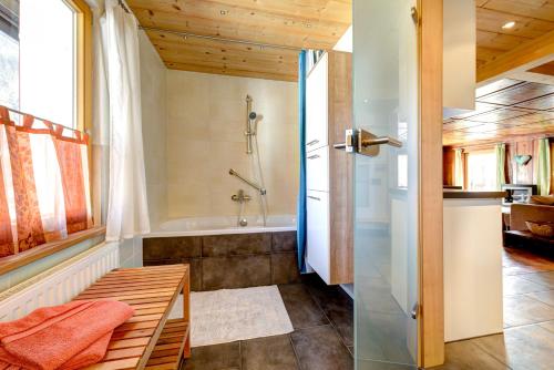 a bathroom with a shower and a bath tub at Appartement Walserstuba by A-Appartments in Brand