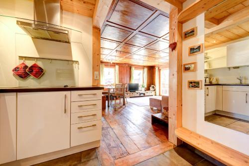 a kitchen with white cabinets and a living room at Appartement Walserstuba by A-Appartments in Brand