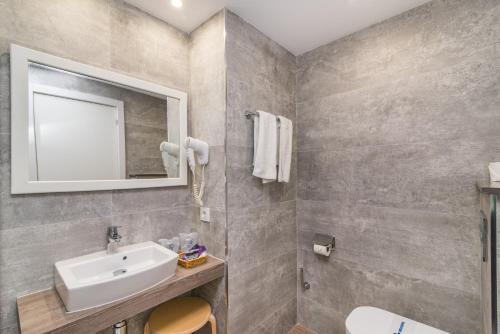 a bathroom with a sink and a mirror at Hotel Na Taconera in Cala Ratjada