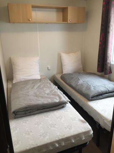 - 2 lits dans une petite chambre avec un matelas dans l'établissement Mobil home 6 pers, 3 ch, Kerlann**** Bretagne Sud, à Pont-Aven