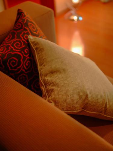 a pillow sitting on a couch with a red and white pillow at Grandia Housen in Awara
