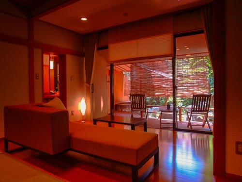 a living room with a couch and a table at Grandia Housen in Awara