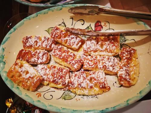 a plate of french fries with powdered sugar on it at Palazzo Gambuzza in Ispica