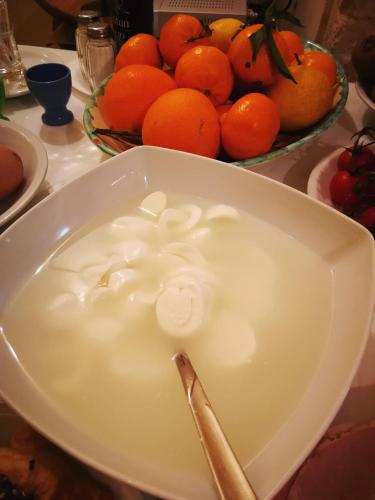 a bowl of milk with a spoon in front of a bowl of oranges at Palazzo Gambuzza in Ispica