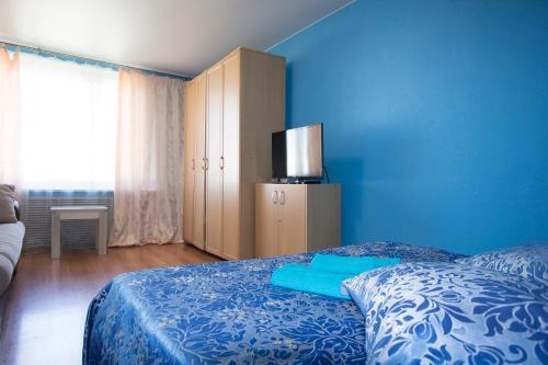 a bedroom with a bed and a blue wall at ApartLux Sokolnicheskaya Superior in Moscow