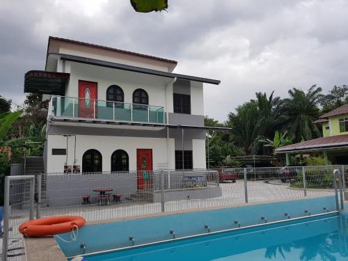 a house with a pool in front of it at MRI Residence - Homestay in Sg Buloh with Swimming Pool - No Pork&Alcohol Allowed in Bandar Puncak Alam