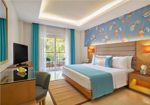 a hotel room with a bed and a television at Movenpick Resort & Spa Boracay in Boracay