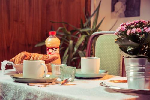 una mesa con dos tazas y un plato de comida en A casa di Nina, en Senigallia
