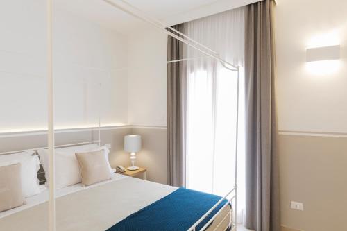 a bedroom with a bed and a large window at Giardino Dei Pini - Boutique Hotel in Alliste