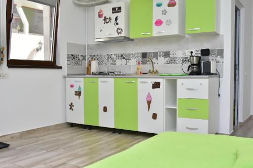 een keuken met groene en witte kasten met ijspatronen bij Cazare Fundeni in Boekarest