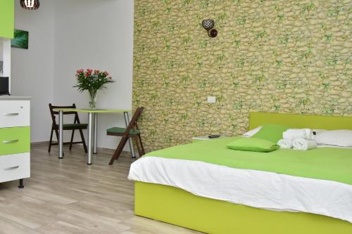 een slaapkamer met een groen bed en een tafel bij Cazare Fundeni in Boekarest