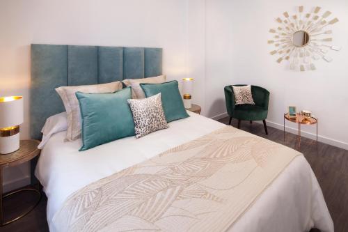 a bedroom with a large bed with a green headboard at INM&aacute;laga Penthouse Padilla in M&aacute;laga