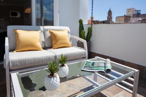 a living room with a couch and a coffee table at INMálaga Penthouse Padilla in Málaga