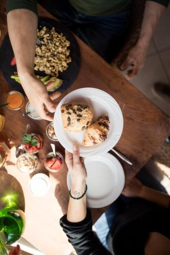 a person holding a bowl of food on a table at Weingut Weidlhof - Suite & Breakfast - Vacation for wine lovers in Caldaro