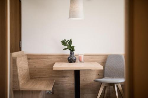 a table and a chair and a vase on a table at Weingut Weidlhof - Suite & Breakfast - Vacation for wine lovers in Caldaro