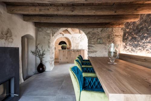 a dining room with a wooden table and blue chairs at Weingut Weidlhof - Suite & Breakfast - Vacation for wine lovers in Caldaro