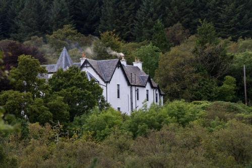 an old white house in the middle of a forest at Linndhu House in Tobermory