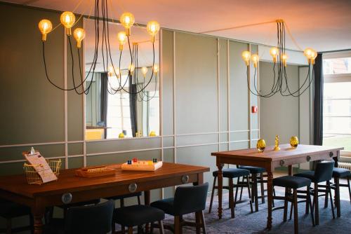 a dining room with two tables and chairs and a mirror at Vienna House Easy by Wyndham Castrop-Rauxel in Castrop-Rauxel