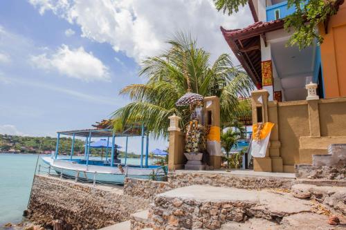 a house with a boat in the water at Aurora Beach View in Nusa Lembongan