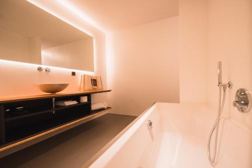 bagno con lavandino e vasca di Hotel Adlernest a Senales