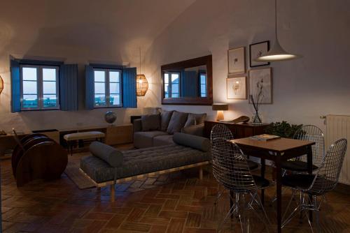 a living room with a couch and a table and chairs at Herdade Do Touril in Zambujeira do Mar