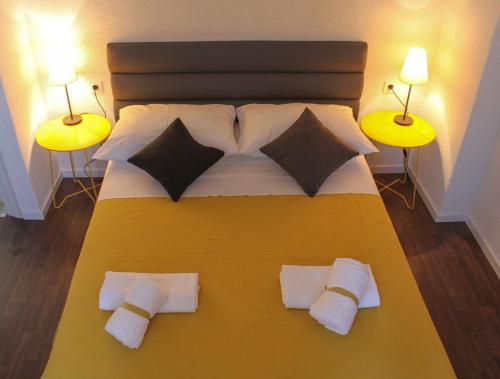 a bedroom with a yellow bed with two lamps at Apartments Kut in Vis