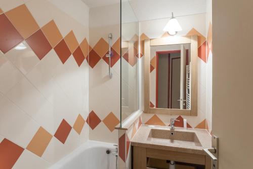 La salle de bains est pourvue d'un lavabo et d'un miroir. dans l'établissement Résidence Pierre & Vacances Le Chamois Blanc, à Chamonix-Mont-Blanc