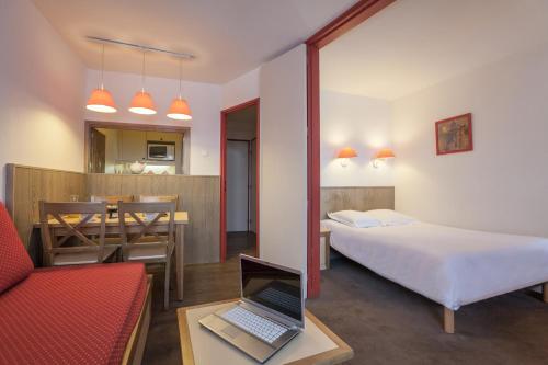 1 dormitorio con cama y mesa con ordenador portátil en Résidence Pierre & Vacances Le Chamois Blanc, en Chamonix-Mont-Blanc