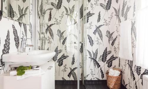 a bathroom with a sink and black and white wallpaper at Bosgårdens Cottages in Broddetorp
