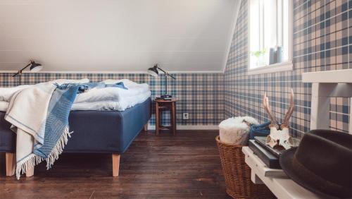 um quarto com uma cama azul e uma janela em Bosgårdens Cottages em Broddetorp