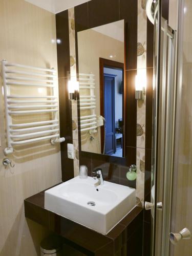 uma casa de banho com um lavatório branco e um espelho. em Eden em Rydzyna