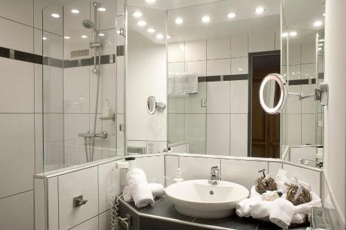 a bathroom with a sink and a shower and a mirror at Parkhotel am Soier See in Bayersoien