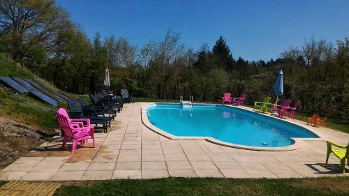 - une piscine avec des chaises colorées dans l'établissement Camping du Puy Rond, à Bressuire