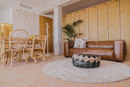 sala de estar con sofá de cuero y mesa en Moll Petit Apartments - Turismo de Interior en Can Picafort