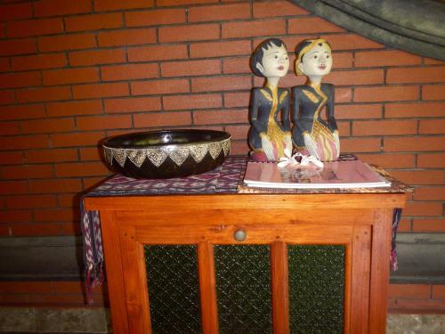 two figurines on a table with a bowl on it at Villa Campi Sorga in Senggigi 