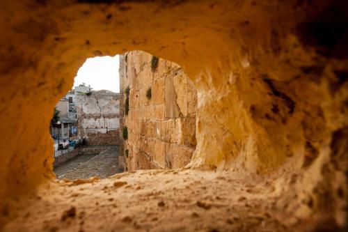 a view through a hole in a stone wall at Hamam Suites Sifaka in Chania Town