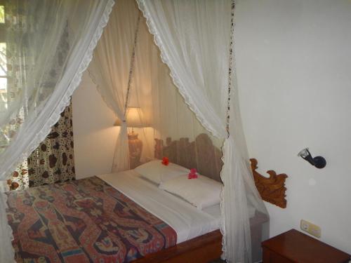 a bedroom with a bed with a swing at Villa Campi Sorga in Senggigi 