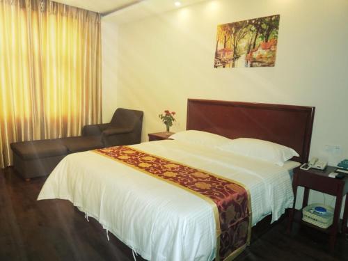 a hotel room with a bed and a chair at GreenTree Inn Henan Zhengzhou Chengnan Road Bojue Business Hotel in Zhengzhou
