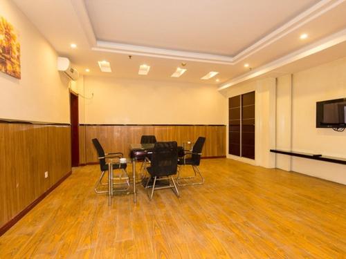 a conference room with a table and chairs in it at GreenTree Inn Henan Zhengzhou Chengnan Road Bojue Business Hotel in Zhengzhou
